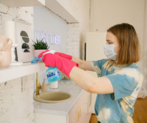 person sanitizing house