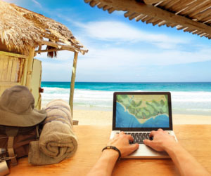 person on computer at beach